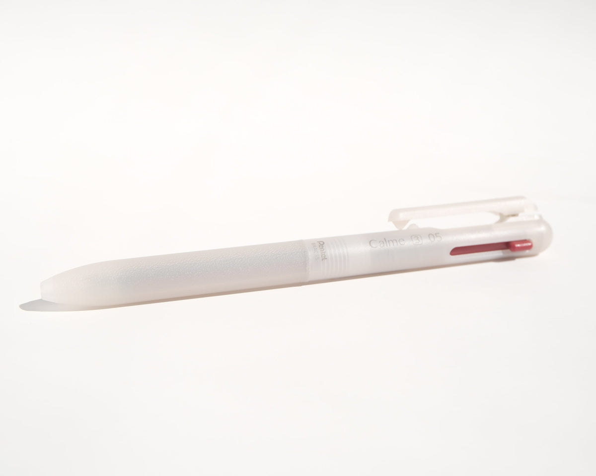 A translucent white multi-color pen with a red ink cartridge visible inside, resting on a plain white surface.