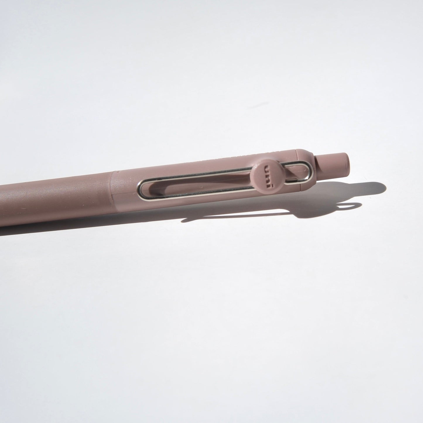Close-up of a beige pen on a light gray background