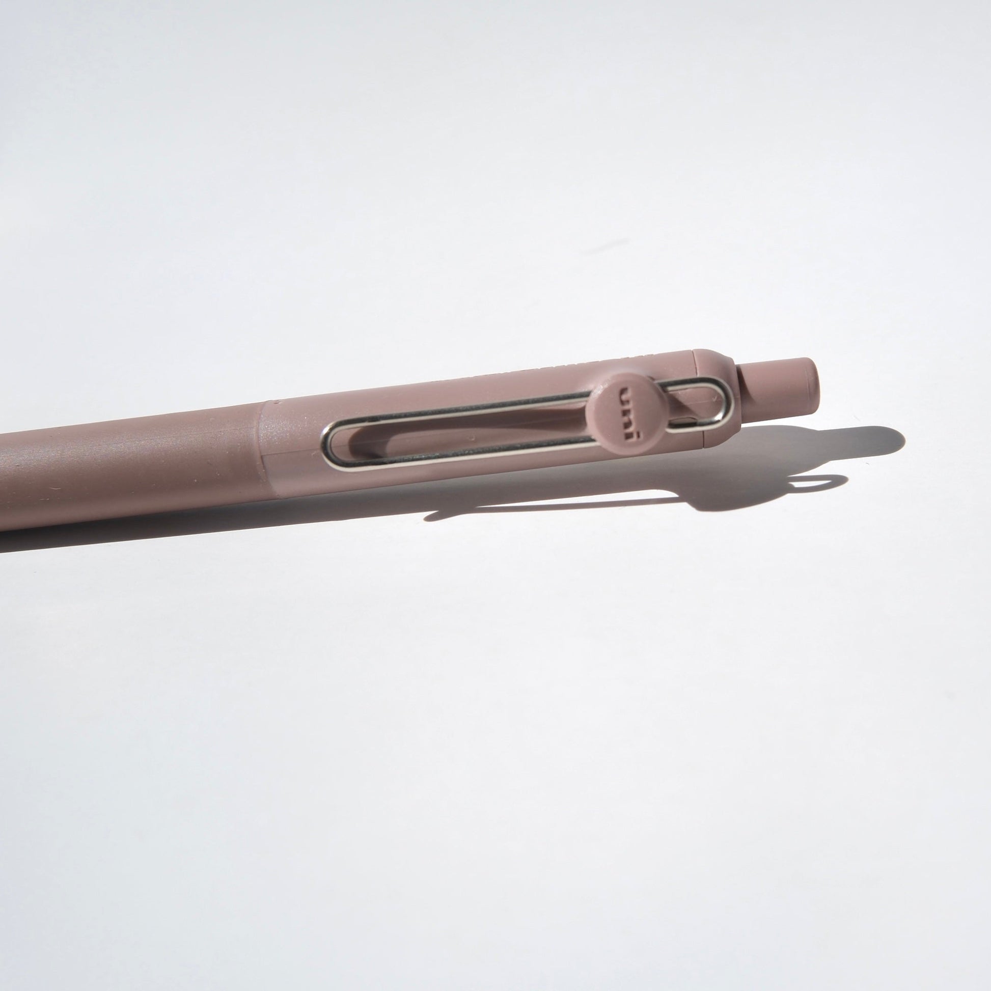 Close-up of a beige pen on a light gray background