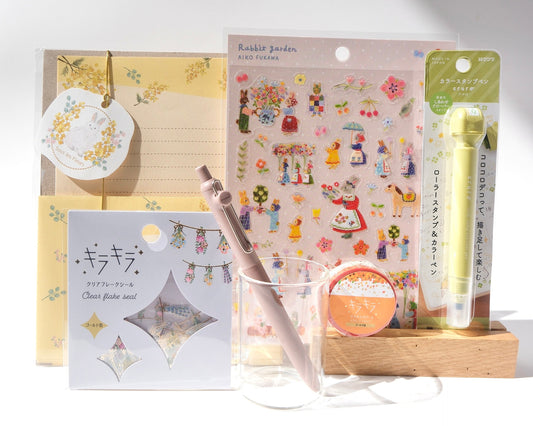 Stationery items including a pen, stickers, and a small notebook on a white background