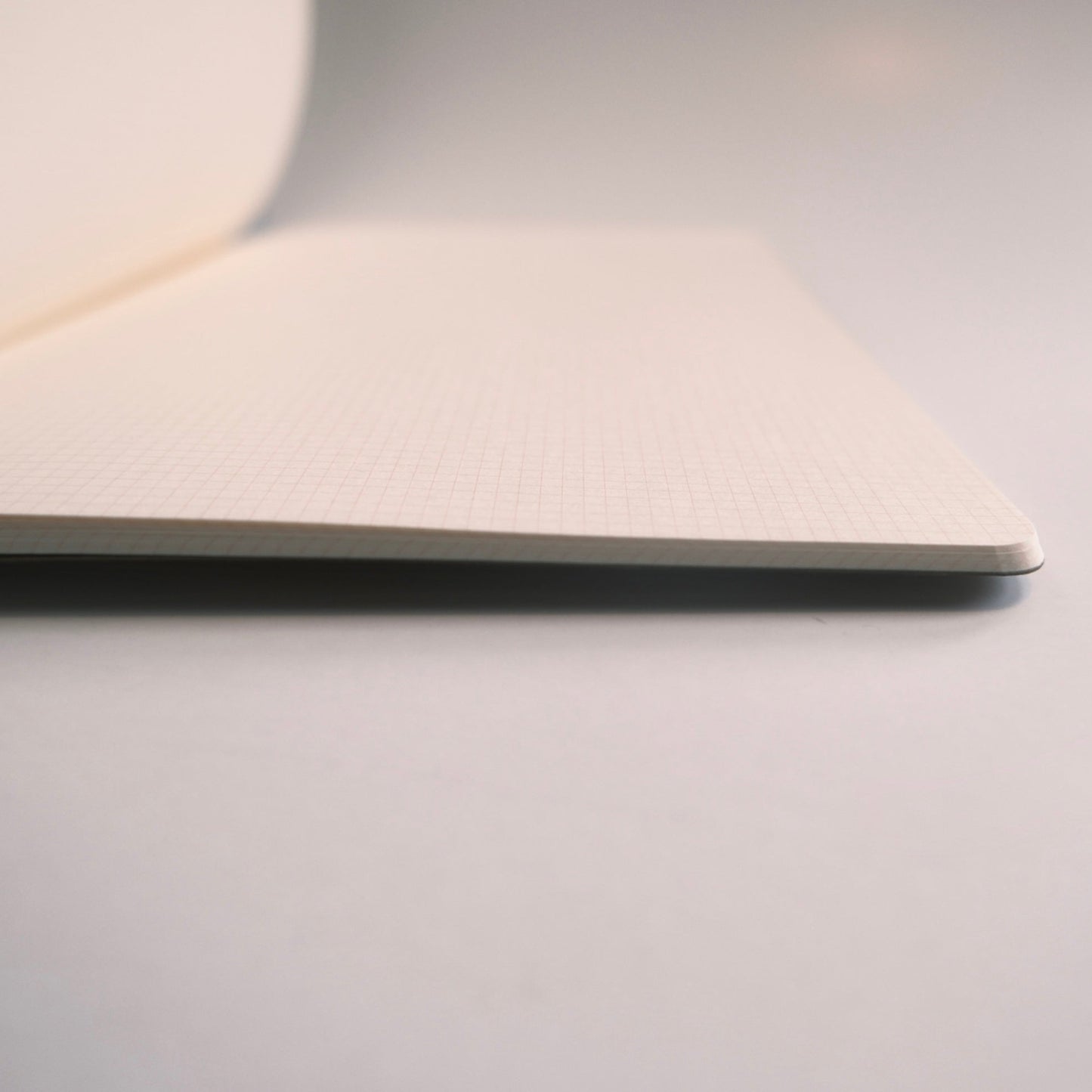 Close-up of Kleid B6 notebook page interior showing thinness and subtle grid lines designed for organized writing and journaling