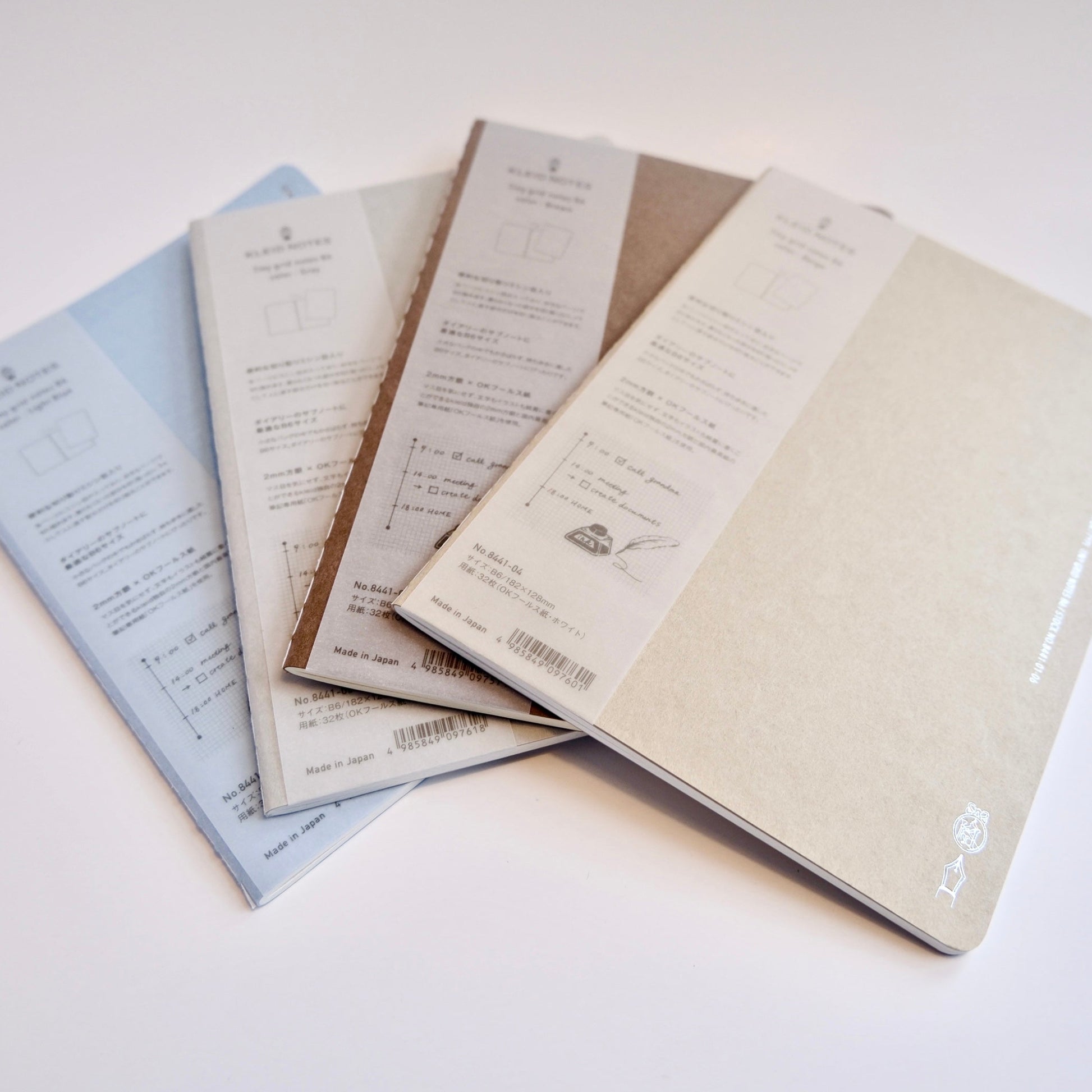 Four notebooks of different colors on a white background. Kleid B6 tiny grid notebook with minimalist Japanese design, ideal for journaling, planning, and everyday writing