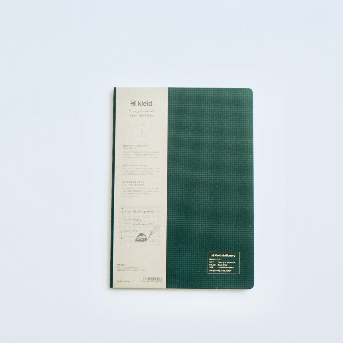 A KLEID notebook with a textured dark green cover and a cream-colored spine band, photographed flat on a light gray background.