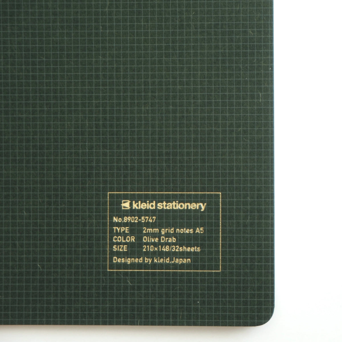 A close-up of a dark green Keld stationery 2mm grid notepad with a white label on the bottom left, set against a plain white background.